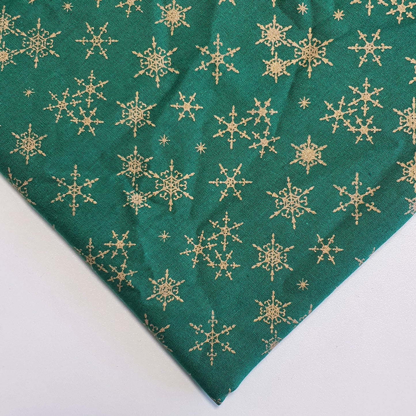green xmas fabric with gold snowflakes print