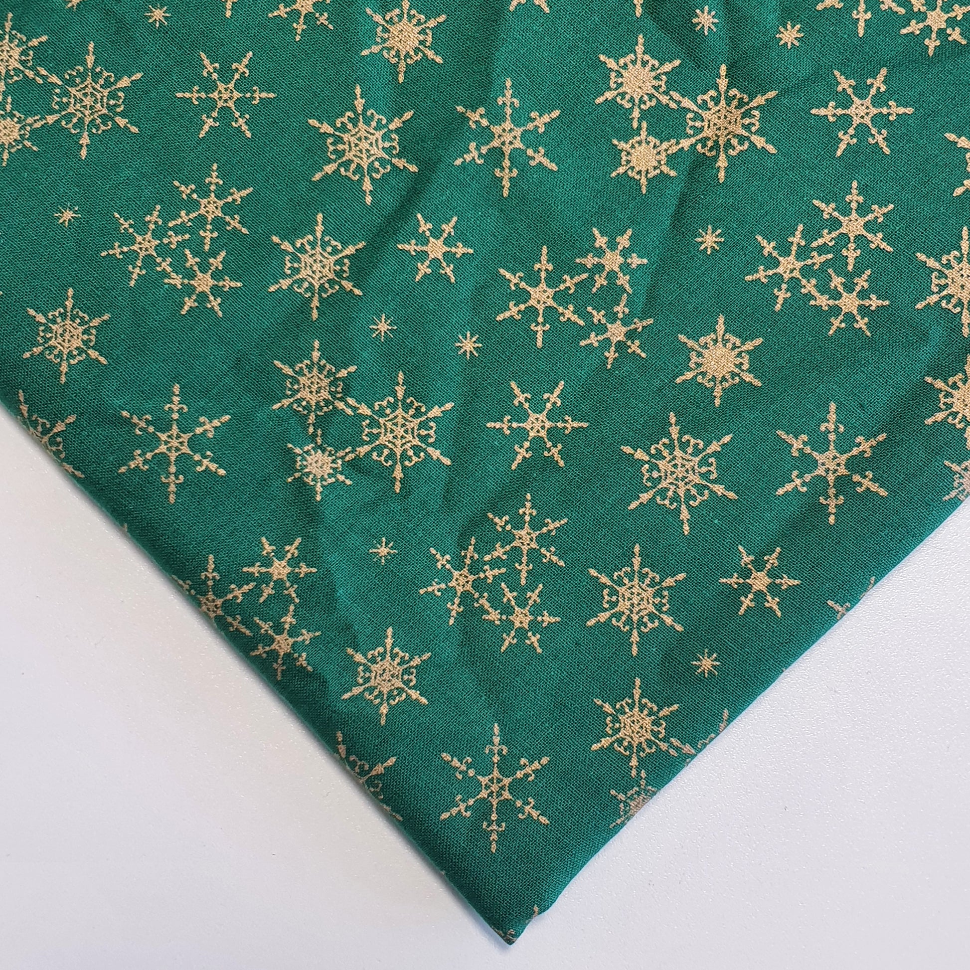green xmas fabric with gold snowflakes print