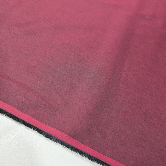 Burgundy 100% cotton chambray fabric draped to showcase its soft lightweight woven texture, 58-inch wide dressmaking fabric sold by the metre.