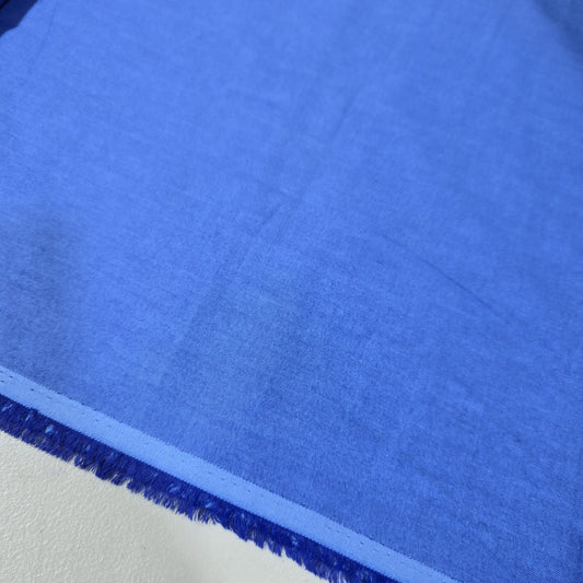 Royal Blue 100% cotton chambray fabric draped to showcase its smooth lightweight woven texture, 58-inch wide dressmaking fabric sold by the metre.