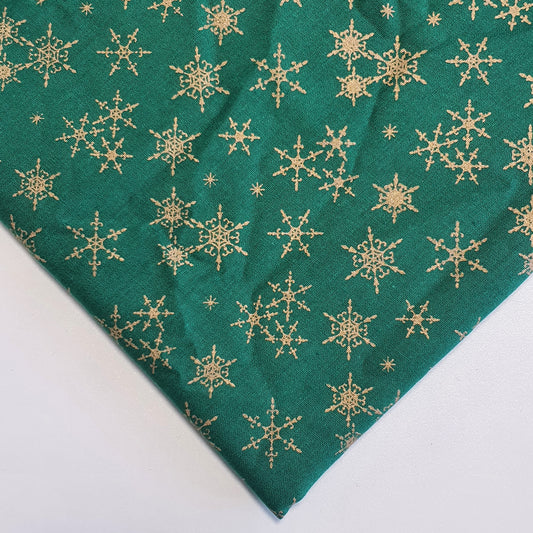 green xmas fabric with gold snowflakes print