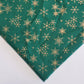 green xmas fabric with gold snowflakes print