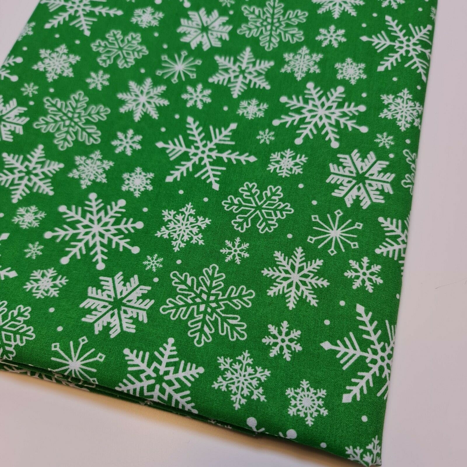 green christmas material by the metre with snowflakes print