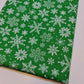 green christmas material by the metre with snowflakes print