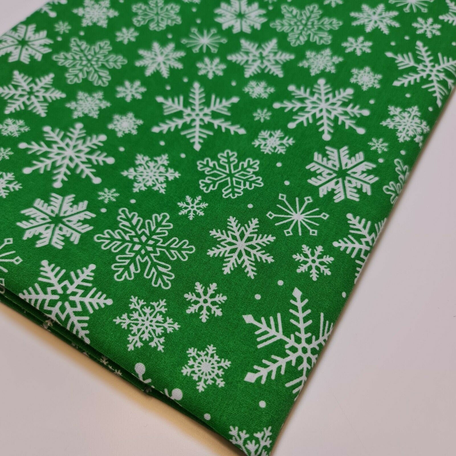 green xmas fabric by the metre with snowflakes print