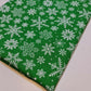 green xmas fabric by the metre with snowflakes print