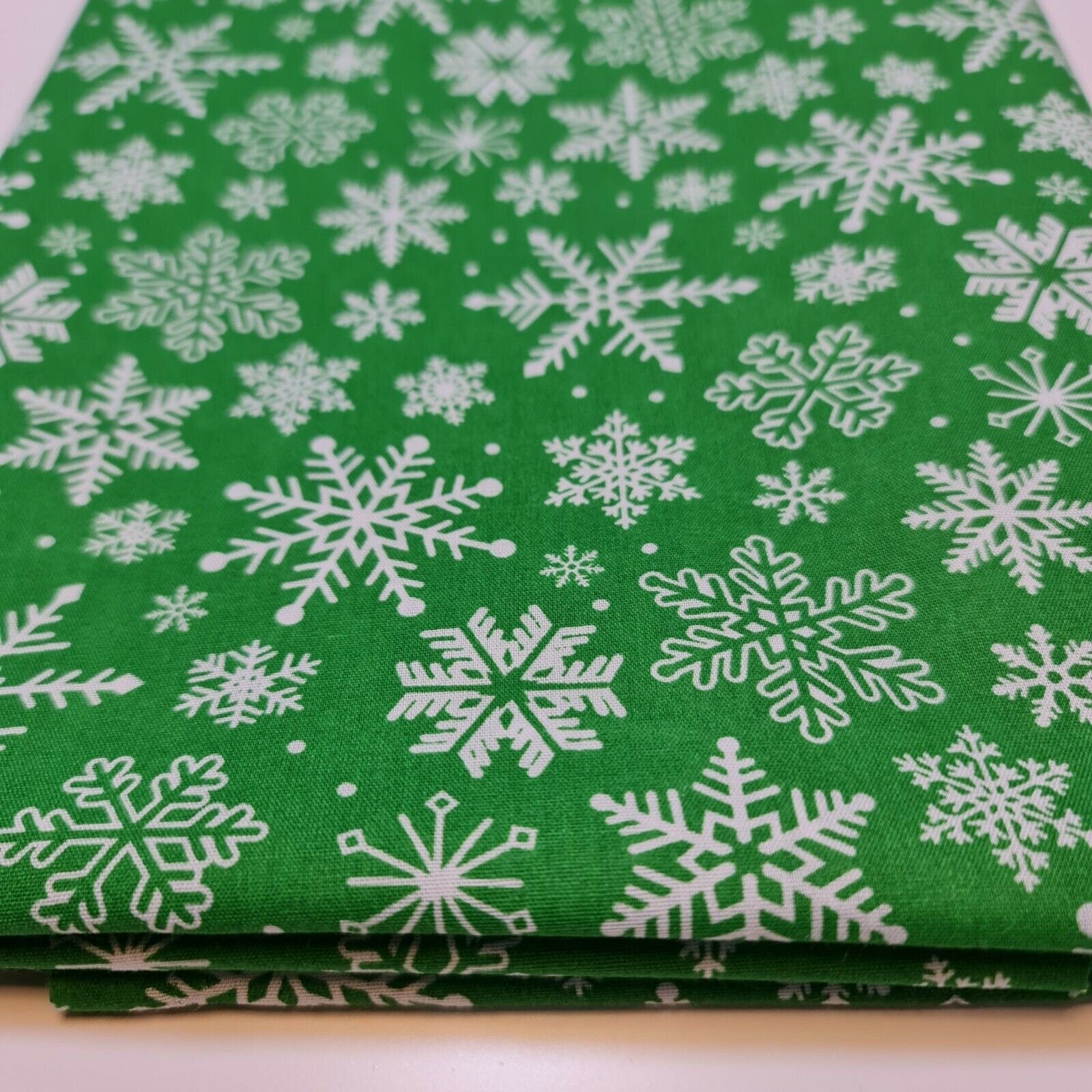 green xmas material by the metre with snowflakes print