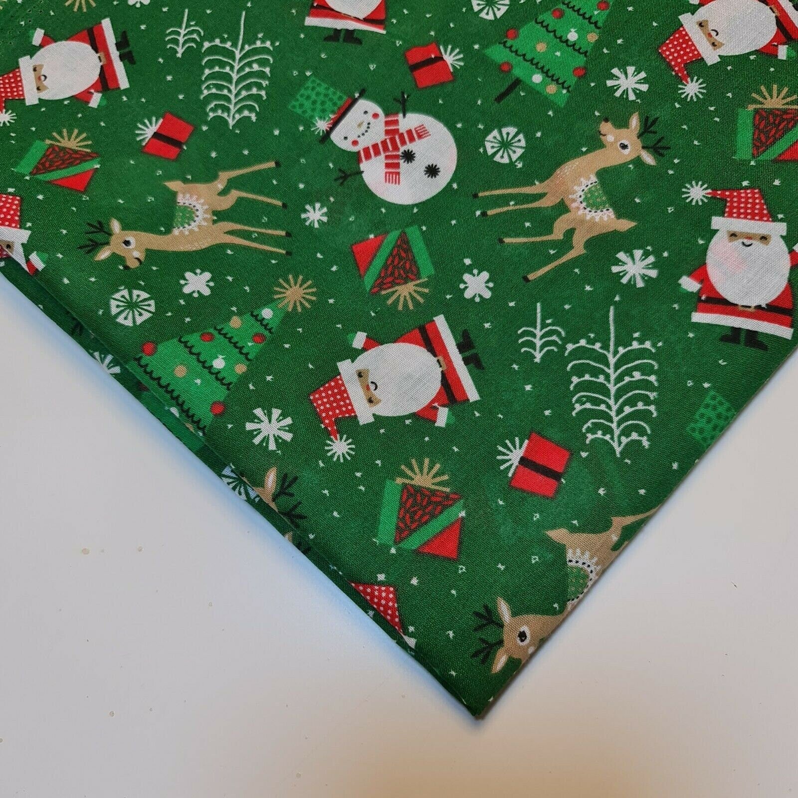 green xmas polycotton material with santa, snowman, reindeer, and tree print