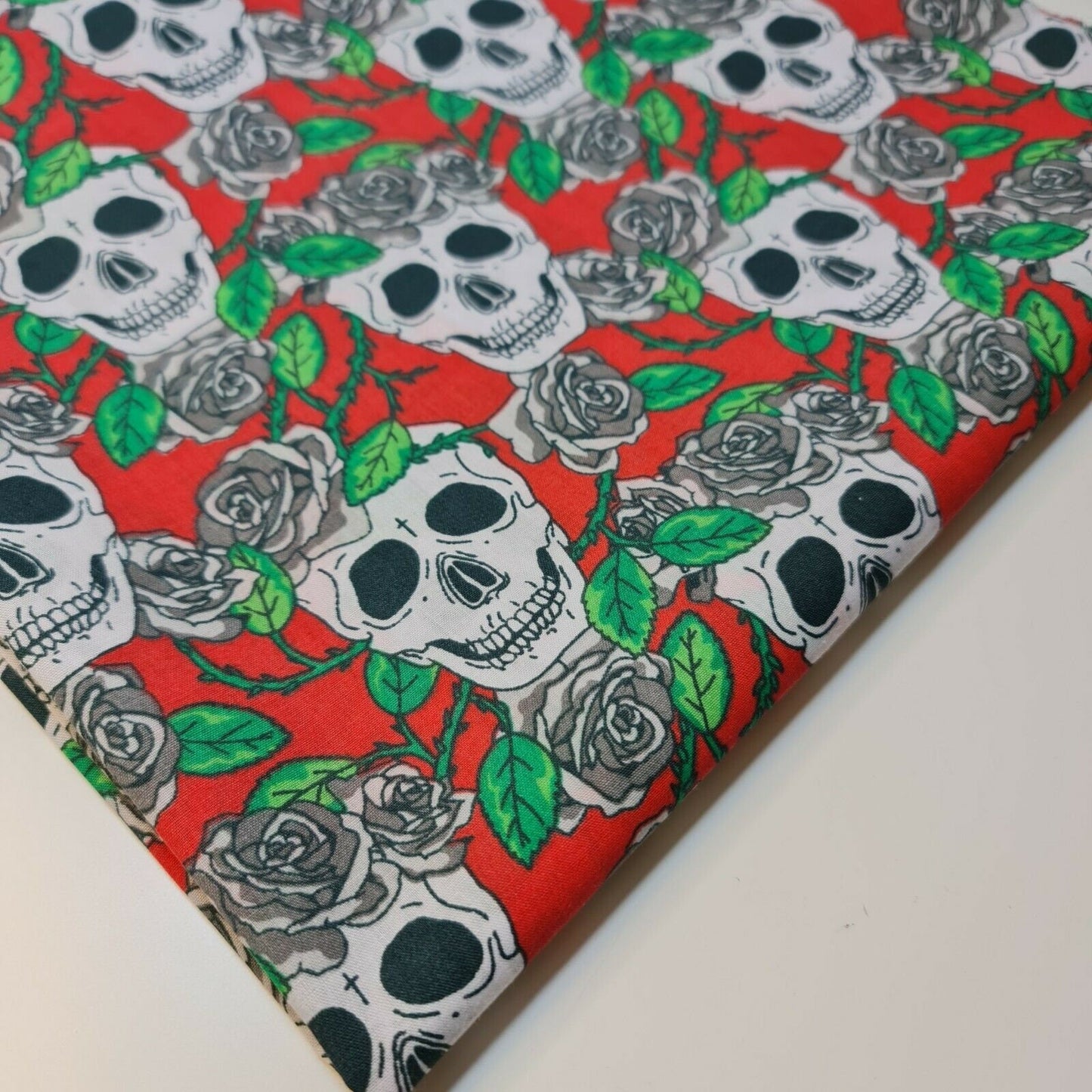 red halloween material fabric with roses and skulls print