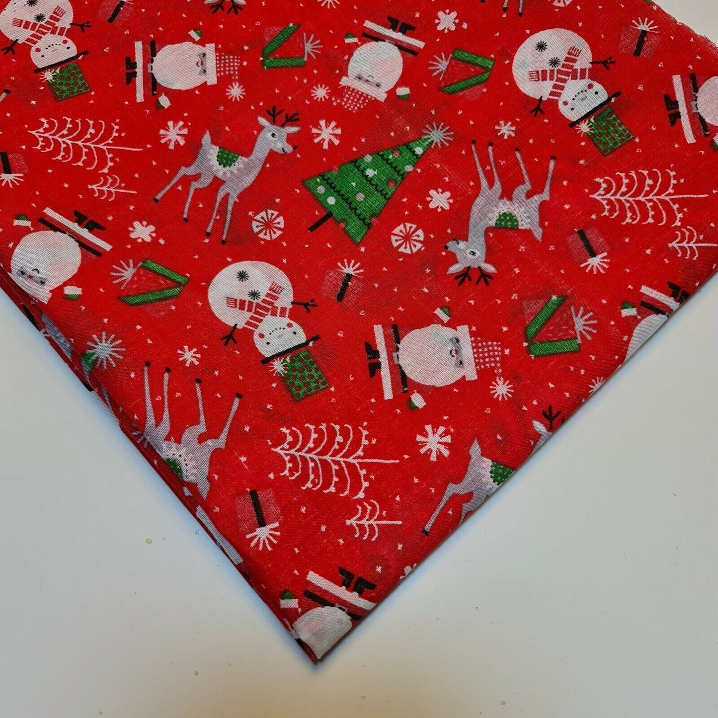 red xmas polycotton material with santa, snowman, reindeer, and tree print