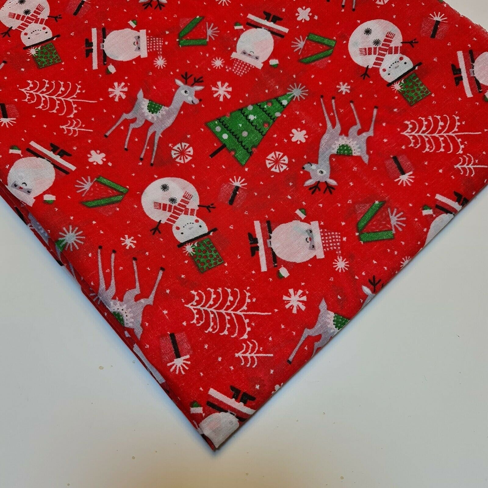 red xmas polycotton material with santa, snowman, reindeer, and tree print